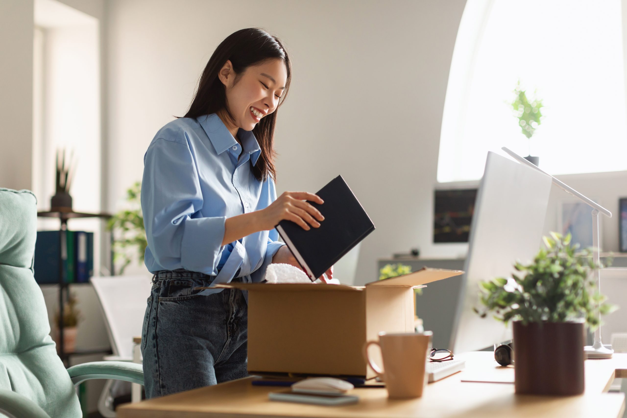 Smiling woman packing up to move to new job